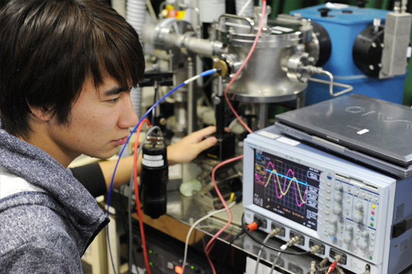 a young man looking at an oscillascope